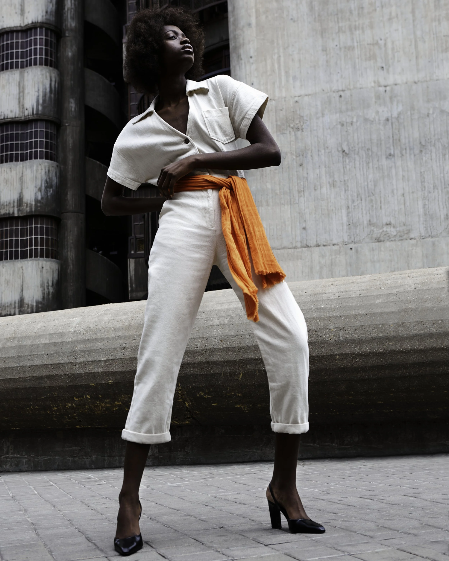 Editorial fashion — Muna, white jumpsuit, brutalist backdrop